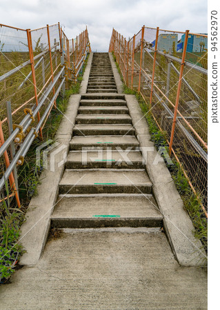 Temporary walkway at a construction site surrounded by fences 94562970