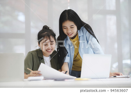 Young asian college university students studying learning discuss working on computer. 94563607
