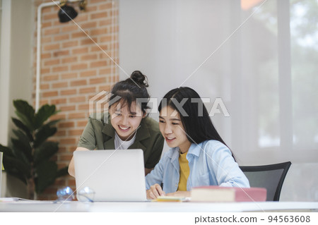 Young asian university students studying learning discuss working on computer. 94563608