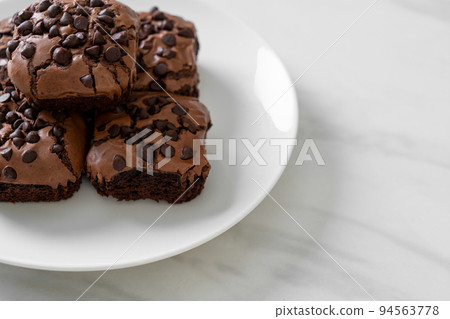 dark chocolate brownies topped by chocolate chips 94563778