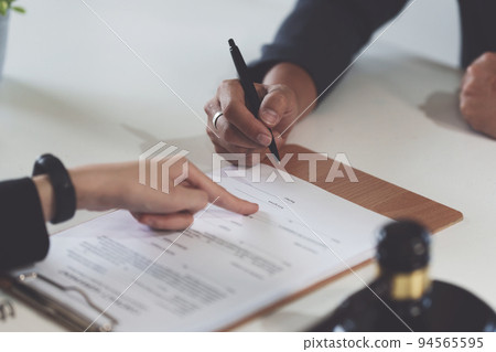 Business woman and lawyers discussing contract papers with brass scale on wooden desk in office. Law, legal services, advice, Justice concept 94565595