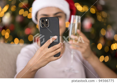 Happy smartphone user taking selfie with flute of wine 94566775