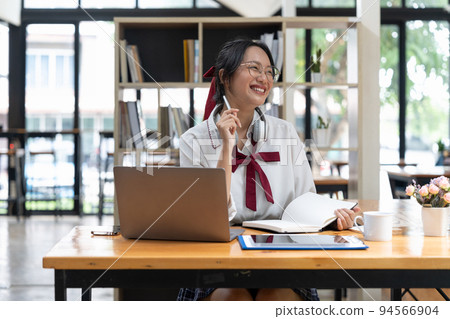 Smiling asian woman takes notes watching webinars on the laptop,researching business tasks, a male student is studying online, listening video lectures, writes down, e-learning concept Smiling asian woman takes notes watching webinars on the laptop,researching business tasks, a male student is studying online, listening video lectures, writes down, e-learning concept 94566904