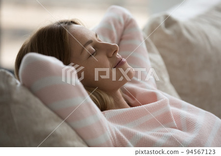 Calm sleepy Caucasian woman relaxing on soft couch 94567123
