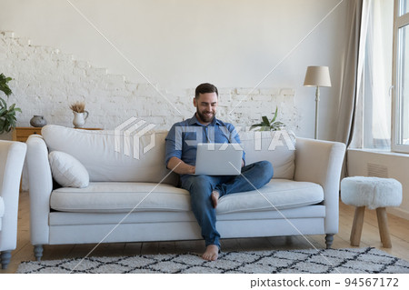 Man spend day off at home using modern laptop Man spend day off at home using modern laptop 94567172