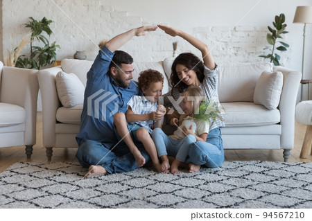 Family with kids sit on floor at their new home Family with kids sit on floor at their new home 94567210