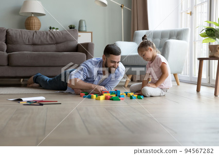 Happy dad and cute little daughter girl playing toy blocks 94567282