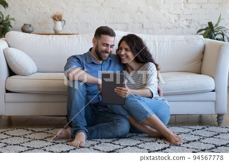 Happy couple buying goods on-line using digital tablet 94567778