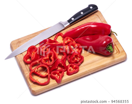 sliced red pepper on wooden cutting board isolated on white background sliced red pepper on wooden cutting board isolated on white background 94568355