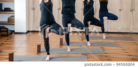Group of women practicing yoga stretching using wooden blocks, exercise for spine and shoulders flexibility 94568804