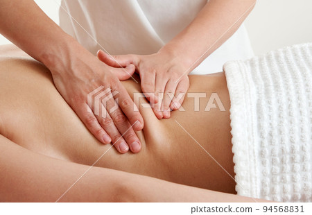 Back massage. Masseur massaging young woman on massage table in spa salon. Young woman relaxing during back massage at the spa. Spa treatment concept Back massage. Masseur massaging young woman on massage table in spa salon. Young woman relaxing during back massage at the spa. Spa treatment concept 94568831