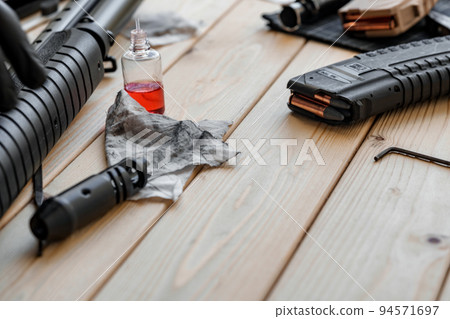 Disassembled rifle with cleaning tools on table of weapons workshop 94571697