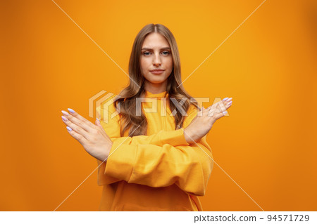 Portrait of attractive girl showing reject sign with crossed arms in studio 94571729