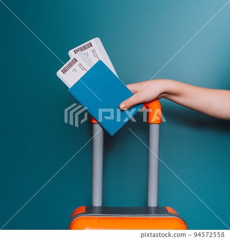 Two tickets in the passport on luggage against blue background 94572558