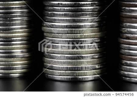 Stacks of metallic coins on a dark background 94574456