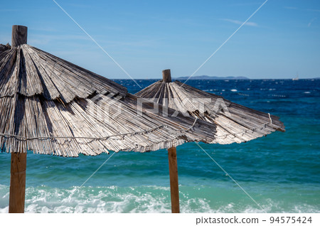 Two sunshades on the beach. Two sunshades on the beach. 94575424
