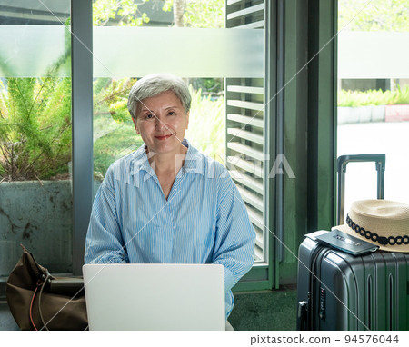 Leisure, vacation, travel, 60-year-old Asian women who are smiling and enjoying themselves while waiting for travel time. Leisure, vacation, travel, 60-year-old Asian women who are smiling and enjoying themselves while waiting for travel time. 94576044