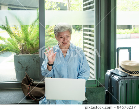 Leisure, vacation, travel, 60-year-old Asian women who are smiling and enjoying themselves while waiting for travel time. Leisure, vacation, travel, 60-year-old Asian women who are smiling and enjoying themselves while waiting for travel time. 94576237