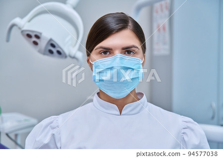 Portrait of female doctor nurse dentist in medical face mask in white 94577038