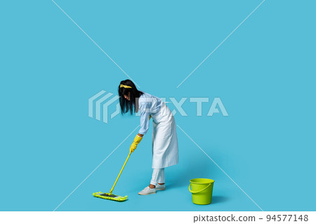 woman in rubber gloves and cleaner apron with cleaning supplies 94577148