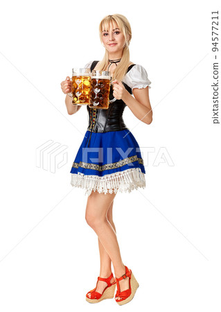 Full length portrait of a blond woman with traditional costume holding beer glasses isolated on white background. 94577211