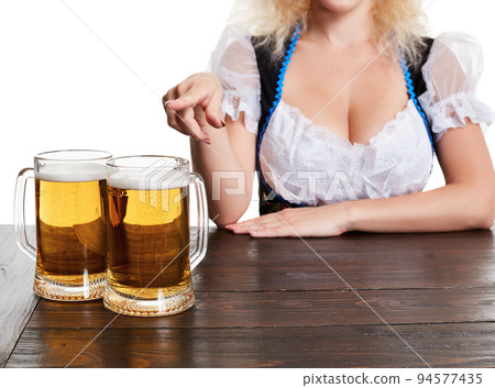 Beautiful young blond girl drinks out of oktoberfest beer stein 94577435