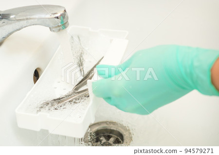Hand in glove cleans the tweezers with water in-tray. Cleaning systems for tweezers Hand in glove cleans the tweezers with water in-tray. Cleaning systems for tweezers 94579271