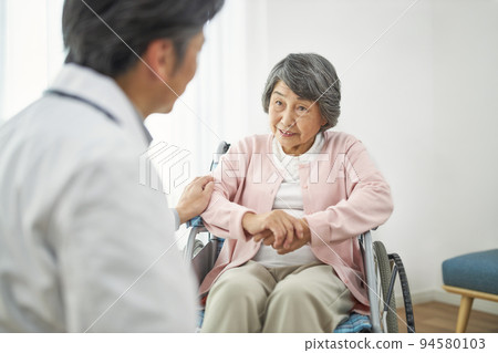 Senior female and male doctor sitting in a wheelchair Senior female and male doctor sitting in a wheelchair 94580103
