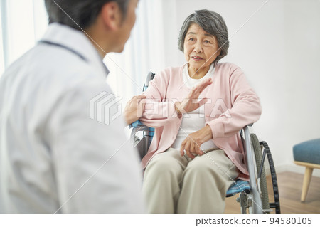 坐在輪椅的資深女性和男性醫生 94580105