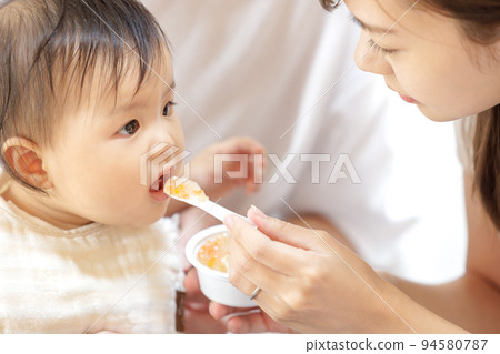 Baby eating baby food 94580787