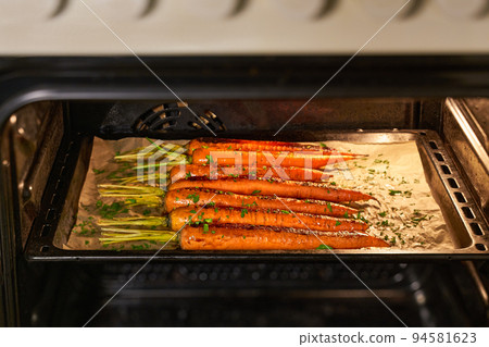 roasted carrots with spices on a baking tray in the oven, selective focus. roasted carrots with spices on a baking tray in the oven, selective focus. 94581623