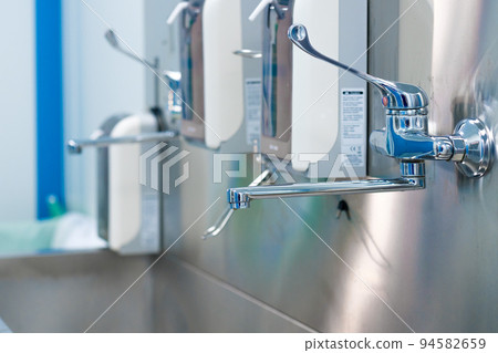 Sterile steel washbasin in modern surgery room. Sterile steel washbasin in modern surgery room. 94582659