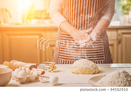 Woman slap his hands above dough closeup. Baker finishing his bakery, shake flour from his hands, free space for text. Woman slap his hands above dough closeup. Baker finishing his bakery, shake flour from his hands, free space for text. 94582910