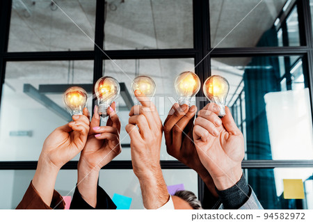 Teamwork and brainstorming concept with businessmen that share an idea with a lamp 94582972