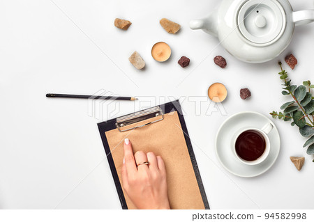 A woman hands writing on empty book note, diary, spread mockup, top view, studio. Cup of coffee break. 94582998