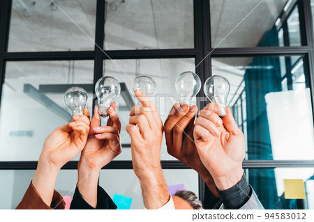 Teamwork and brainstorming concept with businessmen that share an idea with a lamp 94583012