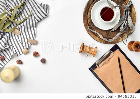 Opened diary with pen on the table near hot cup of black tea 94583013