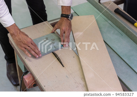 worker cut wood with Metal silver circular saw blades worker cut wood with Metal silver circular saw blades 94583327