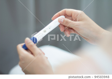 Pregnancy test in hands. The test shows a positive result 94583948