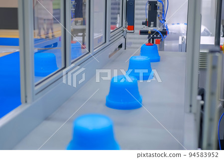 Automatic robotic production line with moving plastic blue pots on conveyor belt Automatic robotic production line with moving plastic blue pots on conveyor belt 94583952