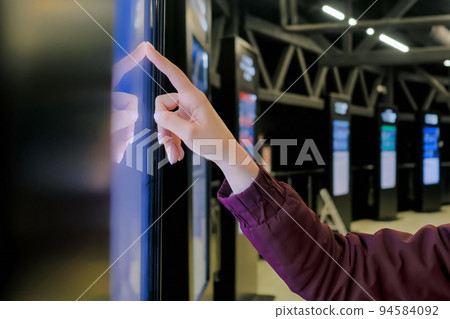 Woman hand using touchscreen display of interactive kiosk at exhibition Woman hand using touchscreen display of interactive kiosk at exhibition 94584092