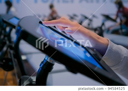 Woman using touchscreen display of floor standing black tablet kiosk: close up Woman using touchscreen display of floor standing black tablet kiosk: close up 94584525