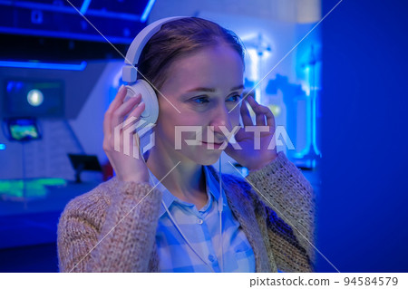 Woman looking at exposition and listening audio guide at exhibition Woman looking at exposition and listening audio guide at exhibition 94584579