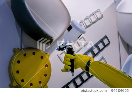 Automatic spray painting robotic arm manipulator during work at exhibition Automatic spray painting robotic arm manipulator during work at exhibition 94584605