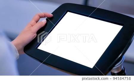 White screen concept - woman looking at display of floor standing tablet kiosk White screen concept - woman looking at display of floor standing tablet kiosk 94584758