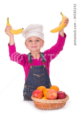 Close-up portrait of a little girl holding fruits - apples, bananas and oranges. Isolated on a light background. 94585242