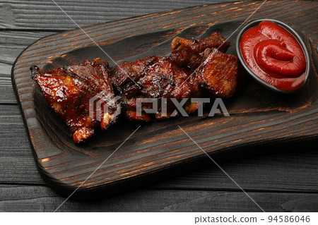 Barbecue spare ribs and BBQ sauce on wooden board 94586046
