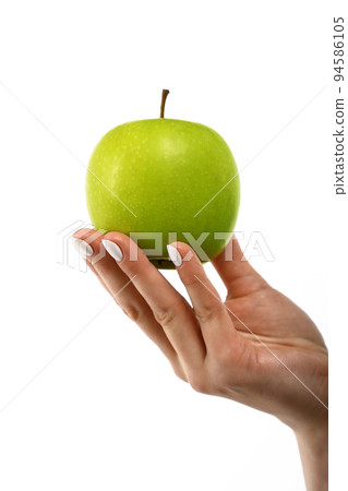 Woman hand holds green apple over white Woman hand holds green apple over white 94586105
