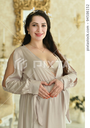 Portrait of a beautiful pregnant woman in a room Portrait of a beautiful pregnant woman in a room 94586152