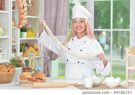 Young woman cooking healthy food in kitchen Young woman cooking healthy food in kitchen 94586153